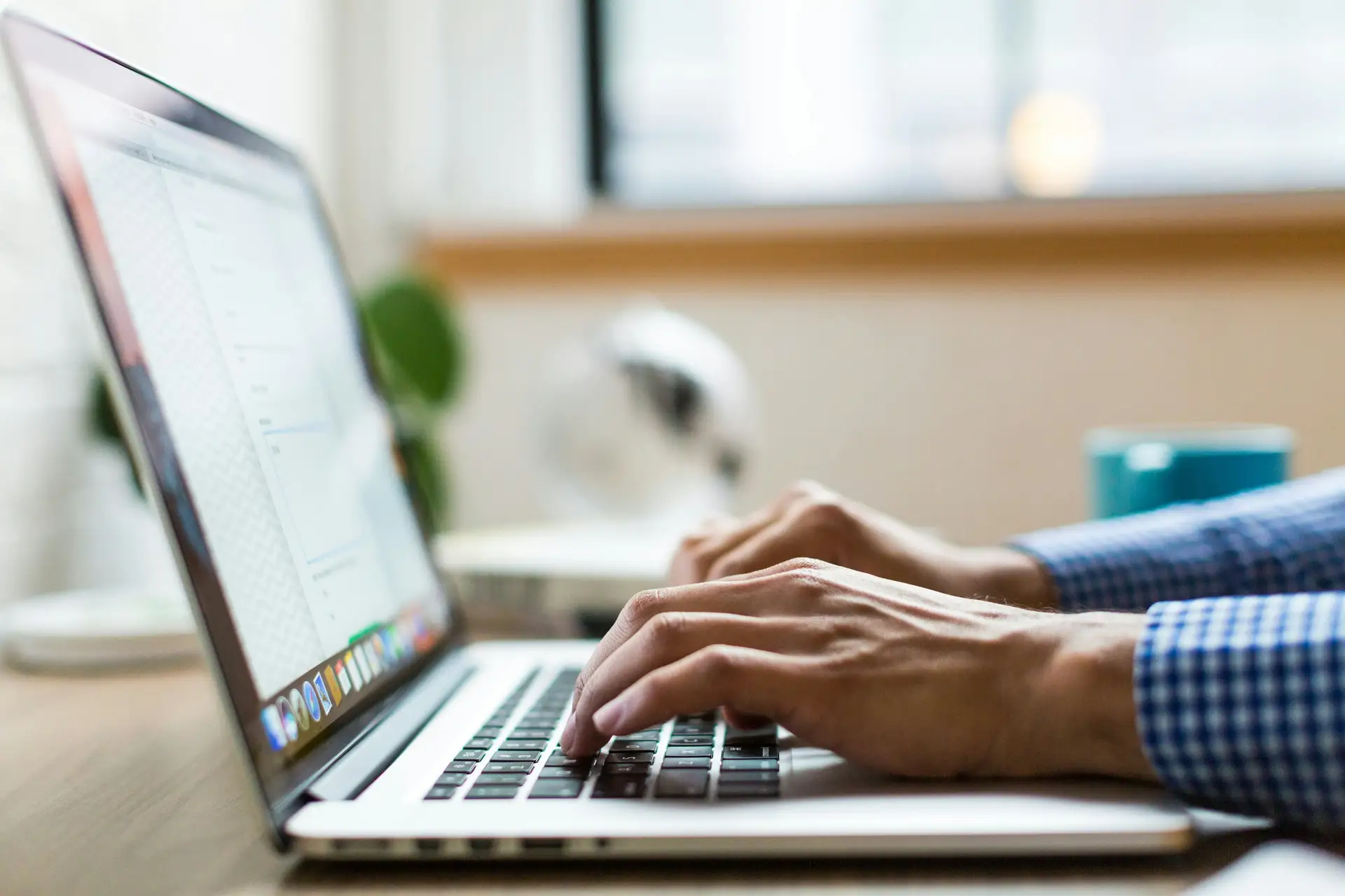 Person arbeitet am Laptop mit geöffnetem Übersetzungs-Editor und zweisprachiger Textansicht
